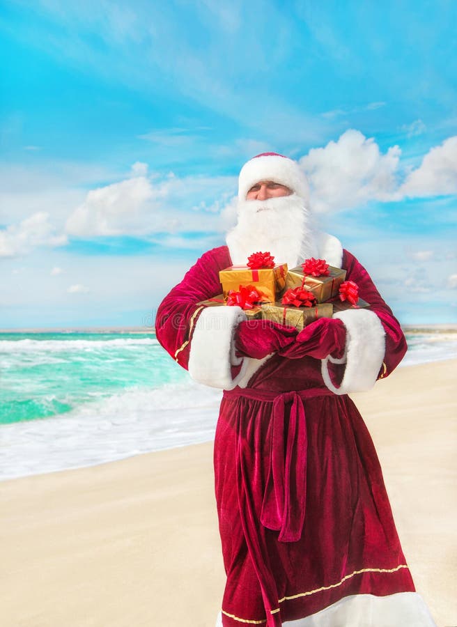 Santa Claus with many golden gifts on sea beach