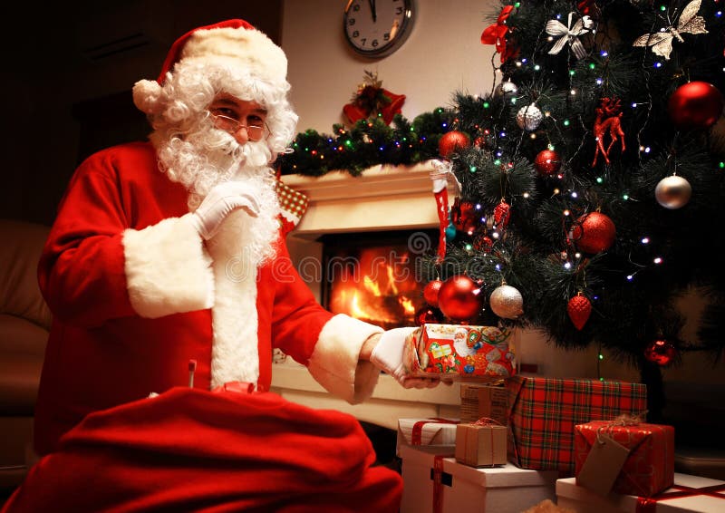 Santa Claus Que Põe a Caixa De Presente Ou O Presente Sob a árvore De Natal Na Noite Da Véspera it é Um Segredo Não Diga As Crian Imagem de Stock - Santa Claus Que Põe a Caixa De Presente Ou O Presente Sob a árvore De Natal Na Noite Da Véspera it é Um Segredo Não Diga As Crian Imagem de Stock -