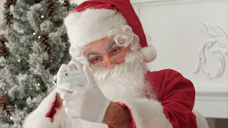 Santa Claus que toma felices selfies en su teléfono imágenes de archivo libres de regalías Santa Claus que toma felices selfies en su teléfono imágenes de archivo libres de regalías