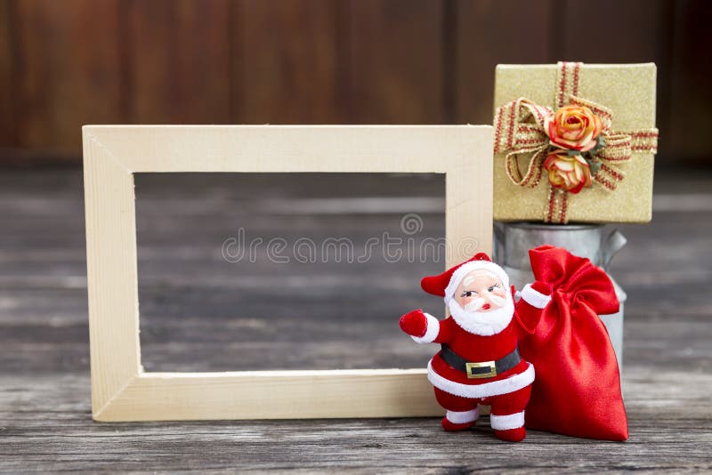 Santa claus with red bag and gift box and wooden picture frame