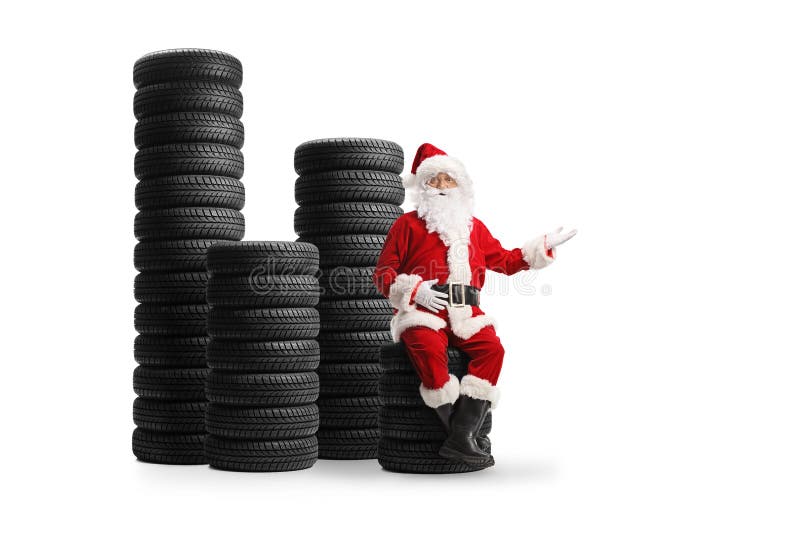 Moș Crăciun așezat pe o grămadă de cauciucuri și gestul unui semn bun venit stock photo