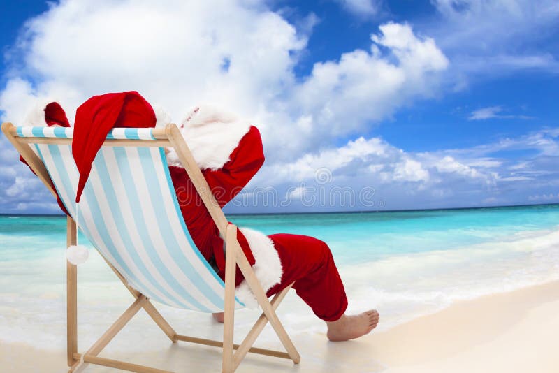 Der Weihnachtsmann sitzt am Strand Stühle mit blauem Himmel und Wolke.