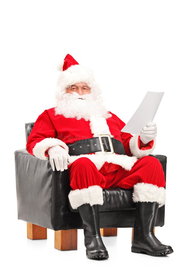 Santa Claus som sitter i fåtölj och läser bokstaven arkivbild Santa Claus som sitter i fåtölj och läser bokstaven arkivbild