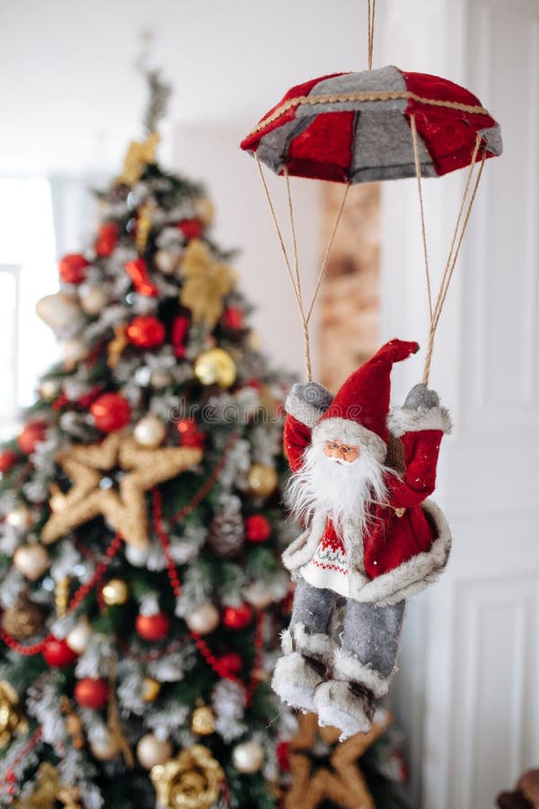 Santa Clause toy on parachute brings gifts at red Christmas tree bokeh background. Big Copyspace concept New Year banner royalty free illustration Santa Clause toy on parachute brings gifts at red Christmas tree bokeh background. Big Copyspace concept New Year banner royalty free illustration