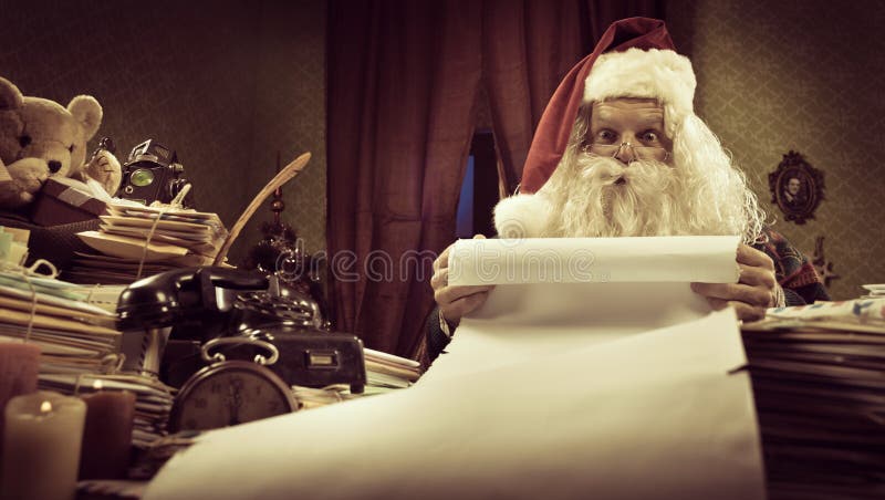Santa with a long Christmas list royalty free stock photo