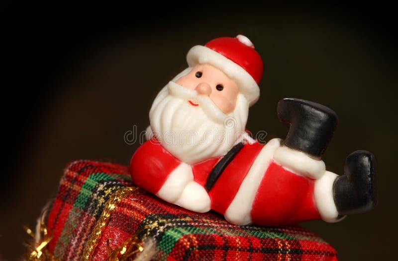 Santa que se reclina sobre un rectángulo de regalo fotografía de archivo Santa que se reclina sobre un rectángulo de regalo fotografía de archivo