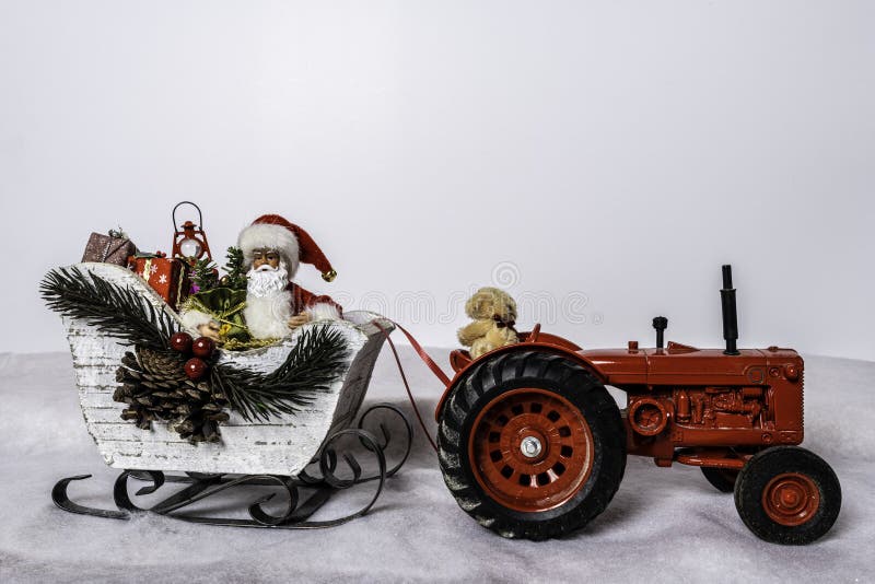 Santa`s sleigh being pulled by a red tractor