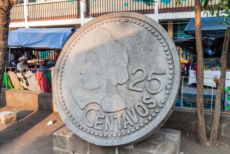 SANTIAGO ATITLAN, GUATEMALA - MARCH 23, 2016: Monument of 25 centavos coin. The bust shows native woman in traditonal garment of Santiago Atitlan village. SANTIAGO ATITLAN, GUATEMALA - MARCH 23, 2016: Monument of 25 centavos coin. The bust shows native woman in traditonal garment of Santiago Atitlan village.