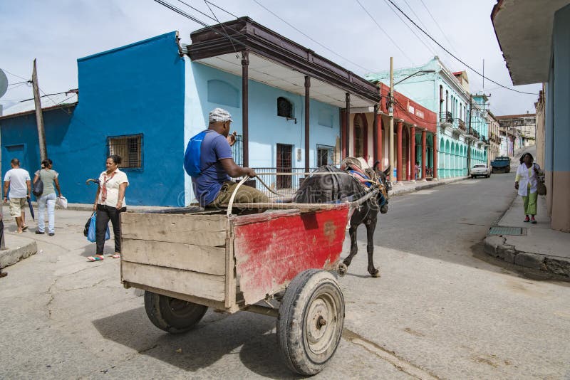 Santiago de Cuba, carro traído por caballo delante de casas coloridas imagen de archivo Santiago de Cuba, carro traído por caballo delante de casas coloridas imagen de archivo