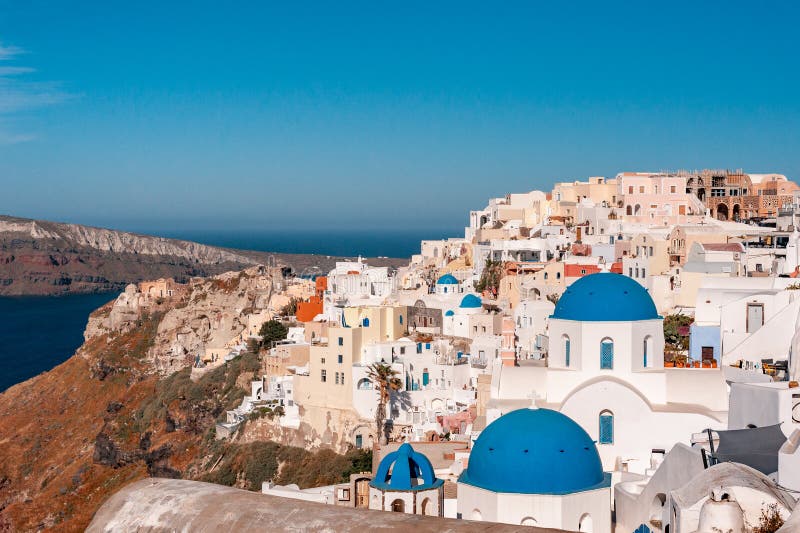 Santorini, Greece. Picturesq view of traditional cycladic Santorini houses on small street with flowers in foreground