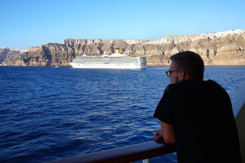 SANTORINI, ГРЕЦИЯ, 18-ОЕ СЕНТЯБРЯ 2018, турист наблюдает красивым ландшафтом кальдеры стоковое фото rf SANTORINI, ГРЕЦИЯ, 18-ОЕ СЕНТЯБРЯ 2018, турист наблюдает красивым ландшафтом кальдеры стоковое фото rf