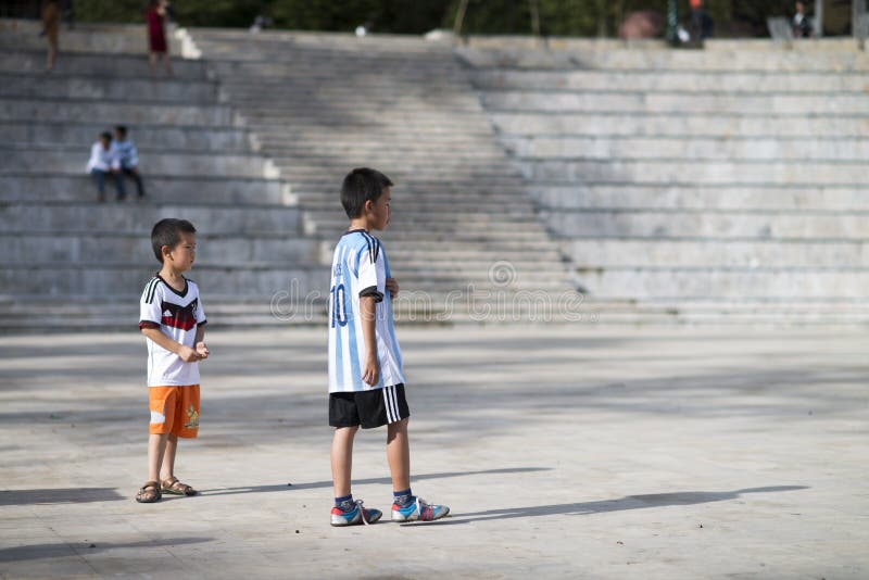 Sapa Lao Cai, Vietnam - 08 17 2014: Två vietnamesiska ungar som spelar fotboll med ärmlös tröjaskjortor av Tyskland och Argentina arkivfoton Sapa Lao Cai, Vietnam - 08 17 2014: Två vietnamesiska ungar som spelar fotboll med ärmlös tröjaskjortor av Tyskland och Argentina arkivfoton