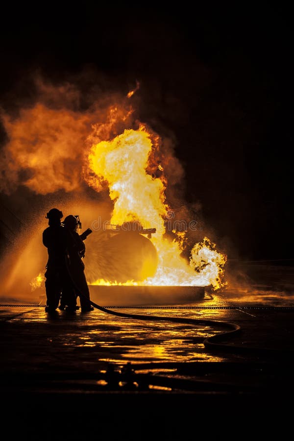 Sapadores-bombeiros que põr para fora um incêndio foto de stock Sapadores-bombeiros que põr para fora um incêndio foto de stock