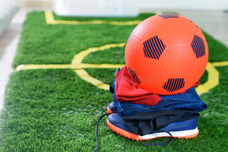 Sapatos de jogador de futebol de bola de futebol e campo de grama