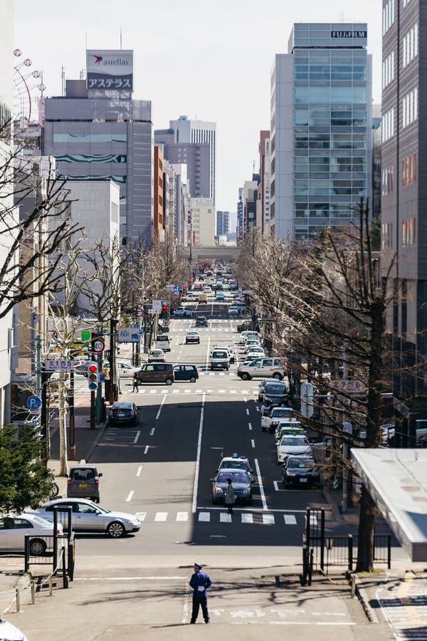 Sapporo cityscape med att gå folk, vägen och rörande bilar i eftermiddagen på Hokkaido, Japan arkivbilder Sapporo cityscape med att gå folk, vägen och rörande bilar i eftermiddagen på Hokkaido, Japan arkivbilder