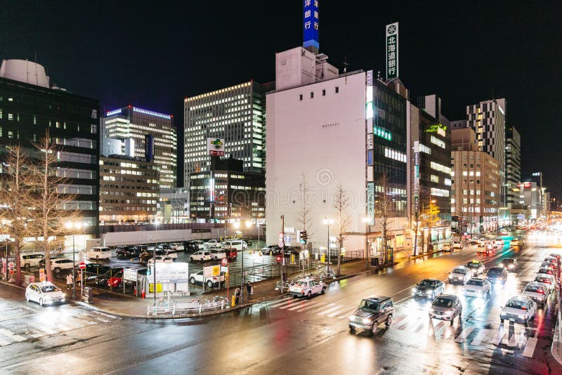 Sapporo nattcityscape med byggnader vänder på ljusen, de rörande bilarna och folket som går i Hokkaido, Japan arkivfoto Sapporo nattcityscape med byggnader vänder på ljusen, de rörande bilarna och folket som går i Hokkaido, Japan arkivfoto