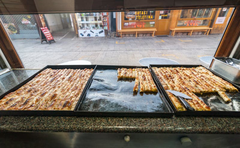 SARAJEVO, BOSNIA - JAN 27, 2018: Famous Bosnian pastry borek bourek with spinach, chease and minced meat in a bourek