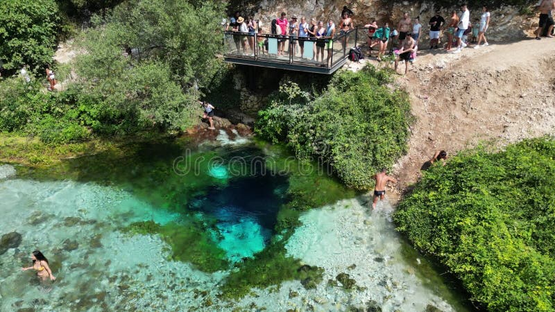 Sarande albania. woensdag 13 september 2023 is het blauwe oog drone - beeld van bovenaf duikende mensen in diep blauw natuurlijk b