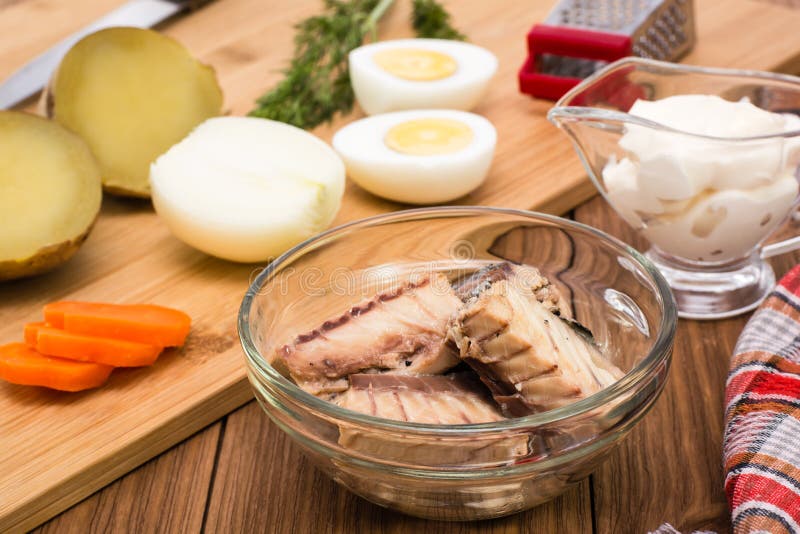 Sardine inscatolate in ciotola ed ingredienti per la preparazione dell'insalata della mimosa immagini stock Sardine inscatolate in ciotola ed ingredienti per la preparazione dell'insalata della mimosa immagini stock