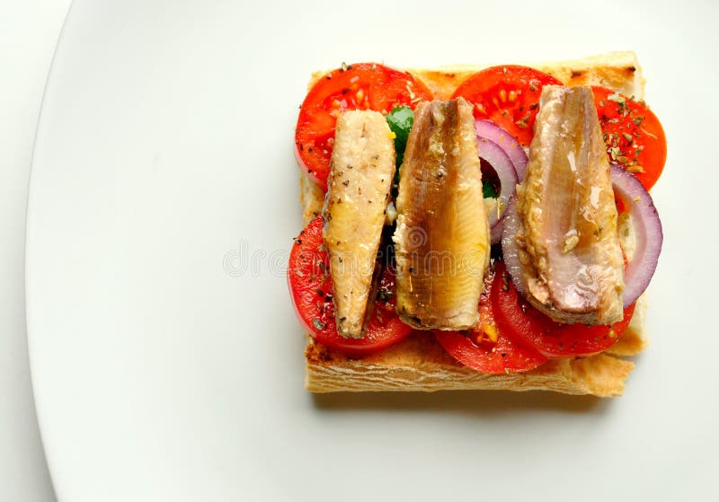 Sardines sandwich with tomato on a white background