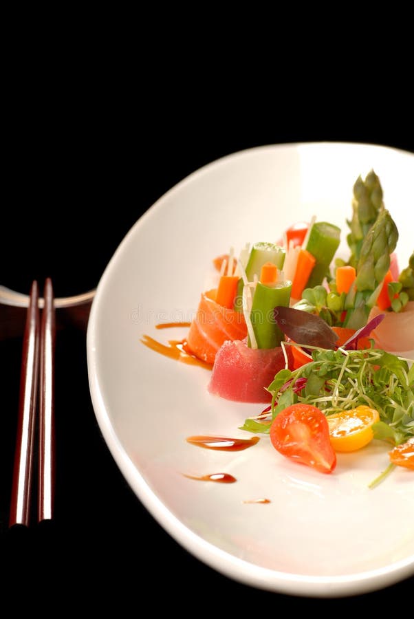 Sashimi on a white plate with chop sticks