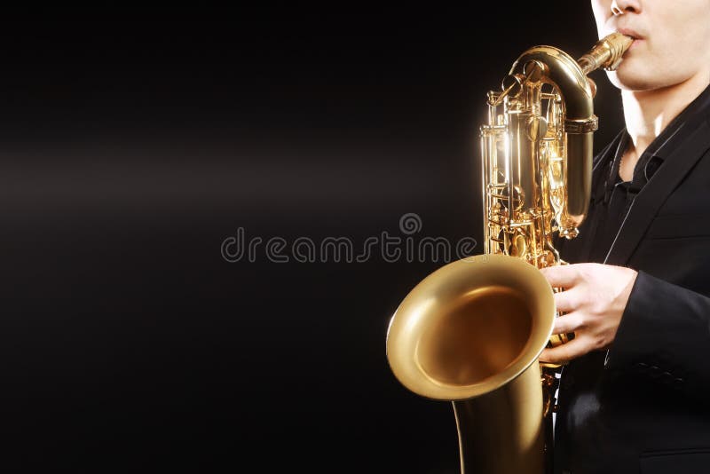 Saxophone jazz musical instruments Saxophonist with Baritone sax details closeup on black. Saxophone jazz musical instruments Saxophonist with Baritone sax details closeup on black
