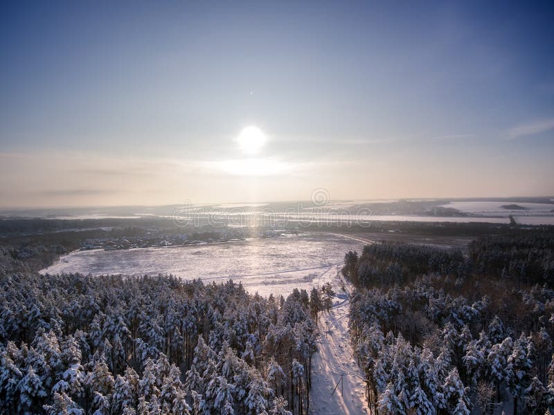 Satellietbeeld op de winterbos en gebied Zonnige dag in sneeuwval, sneeuwvlokken op sunlights Meer en rivier op achtergrond stock foto Satellietbeeld op de winterbos en gebied Zonnige dag in sneeuwval, sneeuwvlokken op sunlights Meer en rivier op achtergrond stock foto