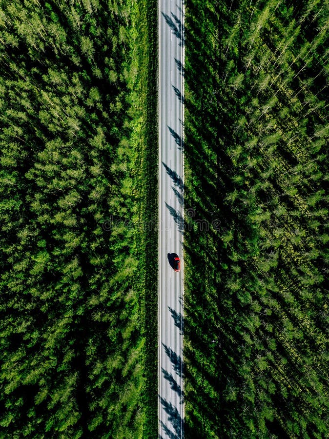 Satellietbeeld van een landweg met rode auto in het midden van groen de zomerbos stock afbeelding Satellietbeeld van een landweg met rode auto in het midden van groen de zomerbos stock afbeelding