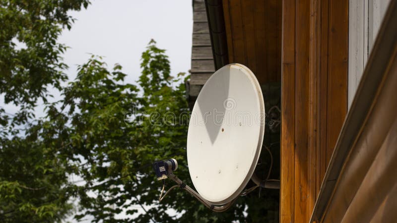 Satellite antenna in the house. White antenna to receive the TV signal. Satellite communications in the village