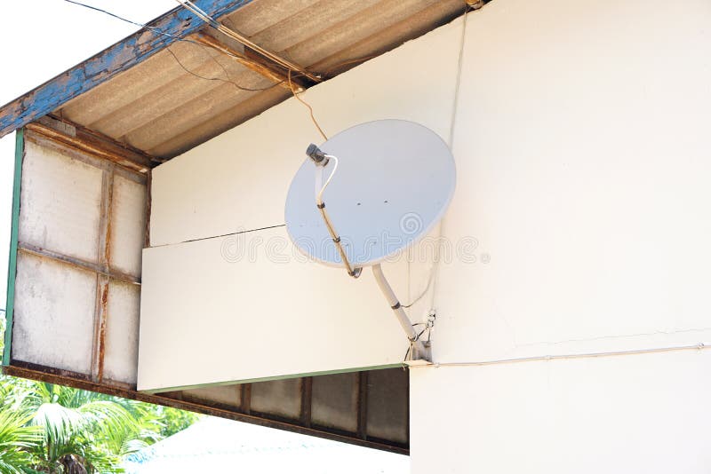 Satellite dish attached to the wall of the house