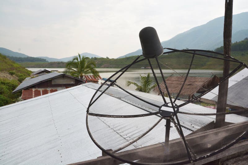 Satellite dish, Telecommunication mast with microwave link and TV transmitter antennas with roof of the house