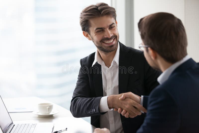 Satisfied happy businessman in suit handshake business partner making deal
