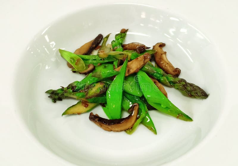 Satued vegetables in a bowl asparagus and mashrooms