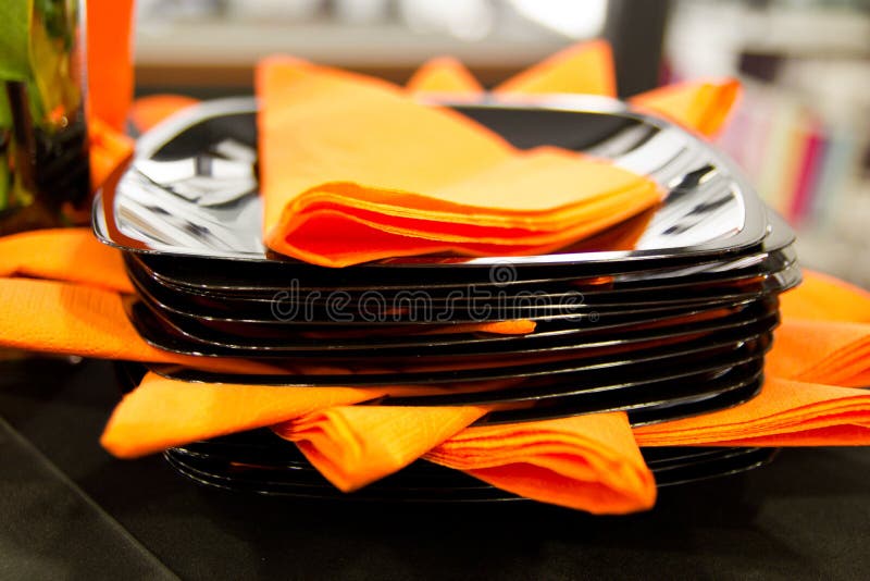 Black saucers and orange napkins photographed with small depth of field. Black saucers and orange napkins photographed with small depth of field