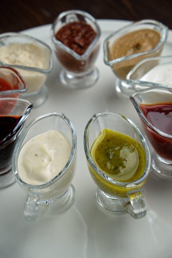 Sauces dans des bols sur fond de bois foncé menu de restauration photographie stock Sauces dans des bols sur fond de bois foncé menu de restauration photographie stock