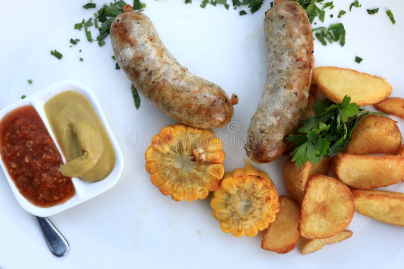 Saucisses avec des légumes et des sauces image stock Saucisses avec des légumes et des sauces image stock