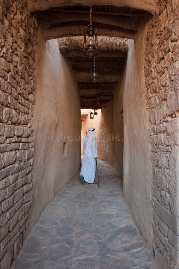 Saudian que camina dentro de las paredes de Al-Ula Old City, saudí Arabi