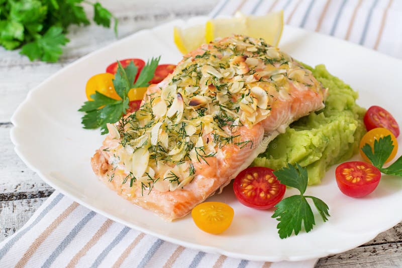 Saumons cuits au four avec du fromage et l'amande, avec de la purée de pommes de terre et les pois photos libres de droits Saumons cuits au four avec du fromage et l'amande, avec de la purée de pommes de terre et les pois photos libres de droits