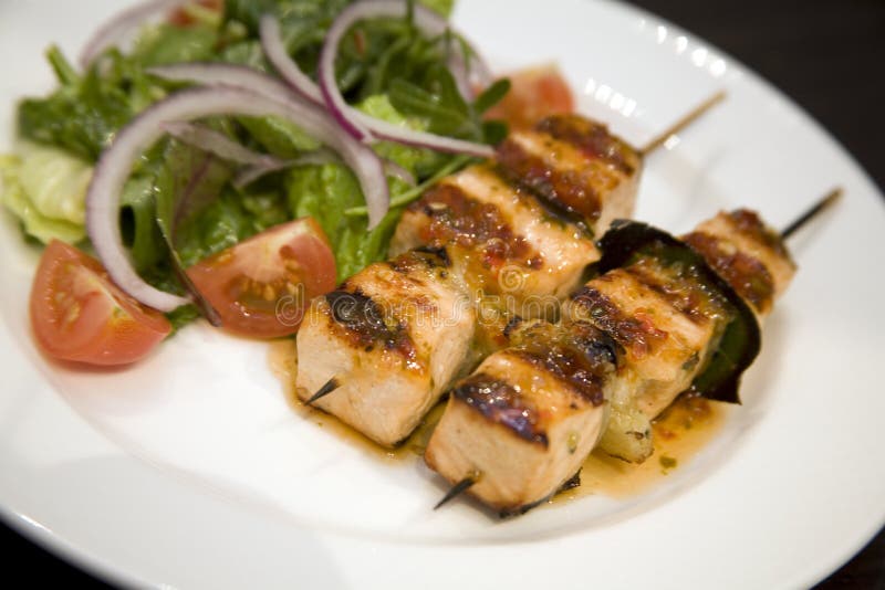 Saumons sur des brochettes avec de la salade image stock