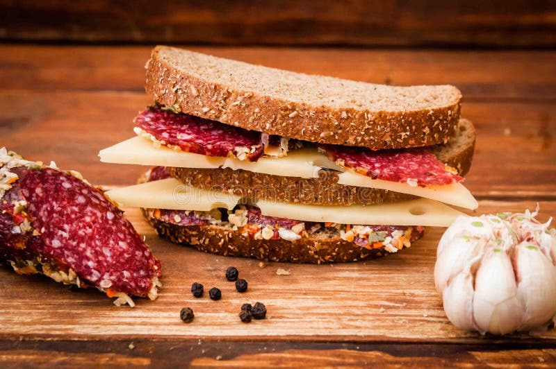 Sausage cooked smoked sausage, cheese with dark for breakfast, sandwich, black bread, garlic, black pepper, bay leaf on the table royalty free stock images Sausage cooked smoked sausage, cheese with dark for breakfast, sandwich, black bread, garlic, black pepper, bay leaf on the table royalty free stock images