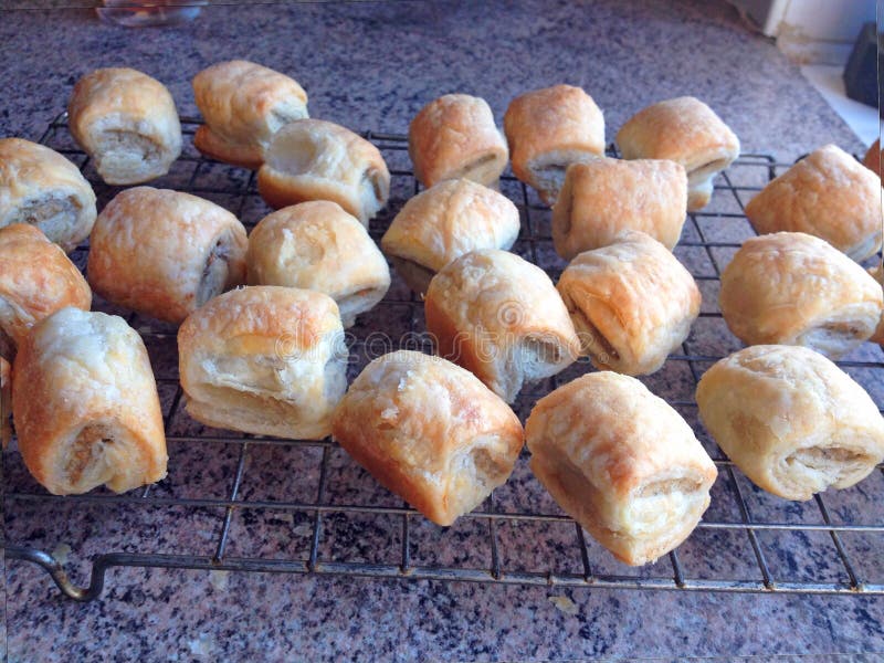 Sausage rolls cooked and cooling on a wire tray. stock photos