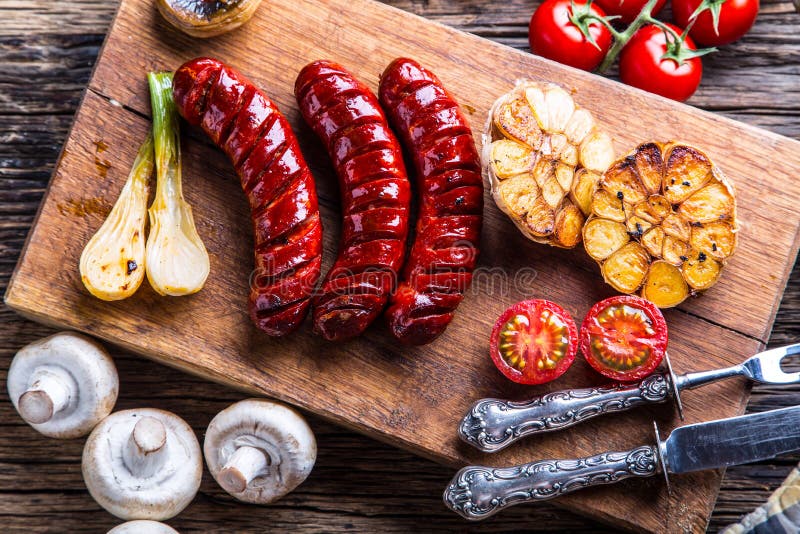 Sausages. Grill sausages. Grilled sausage with mushrooms garlic tomatoes and onions