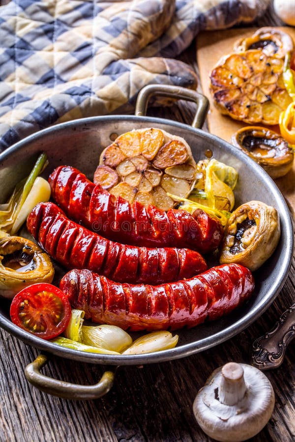 Sausages. Grill sausages. Grilled sausage with mushrooms garlic tomatoes and onions royalty free stock image Sausages. Grill sausages. Grilled sausage with mushrooms garlic tomatoes and onions royalty free stock image