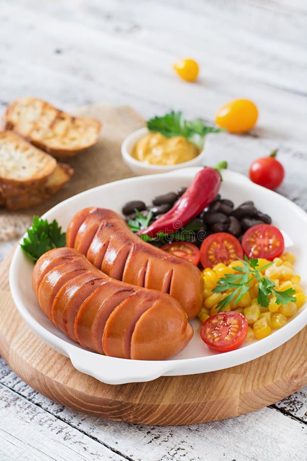 Sausages on the grill with vegetables.