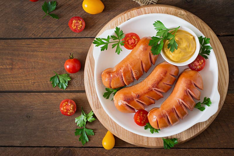 Sausages on the grill with vegetables. Top view