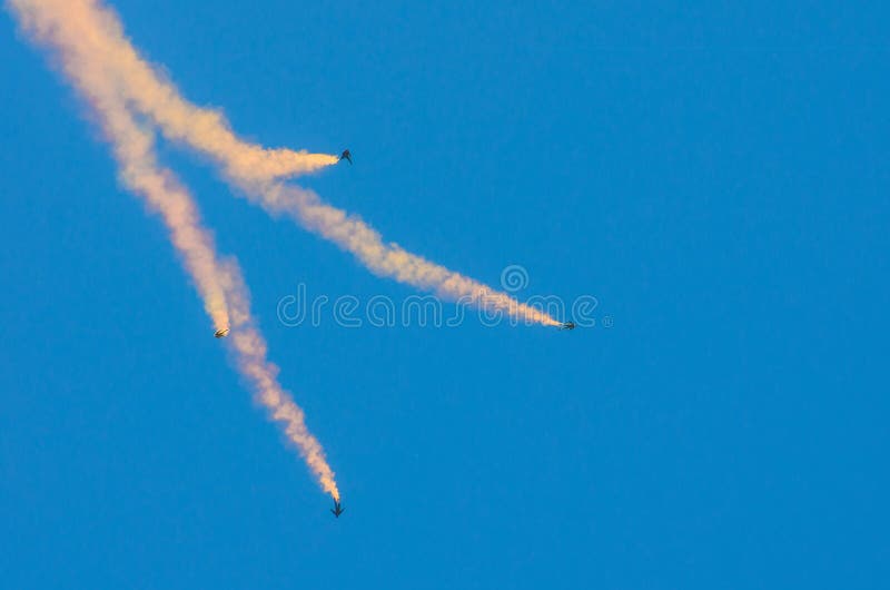 Saut des parachutistes quatre avec de la fumée et la mouche dans le ciel bleu photo libre de droits Saut des parachutistes quatre avec de la fumée et la mouche dans le ciel bleu photo libre de droits