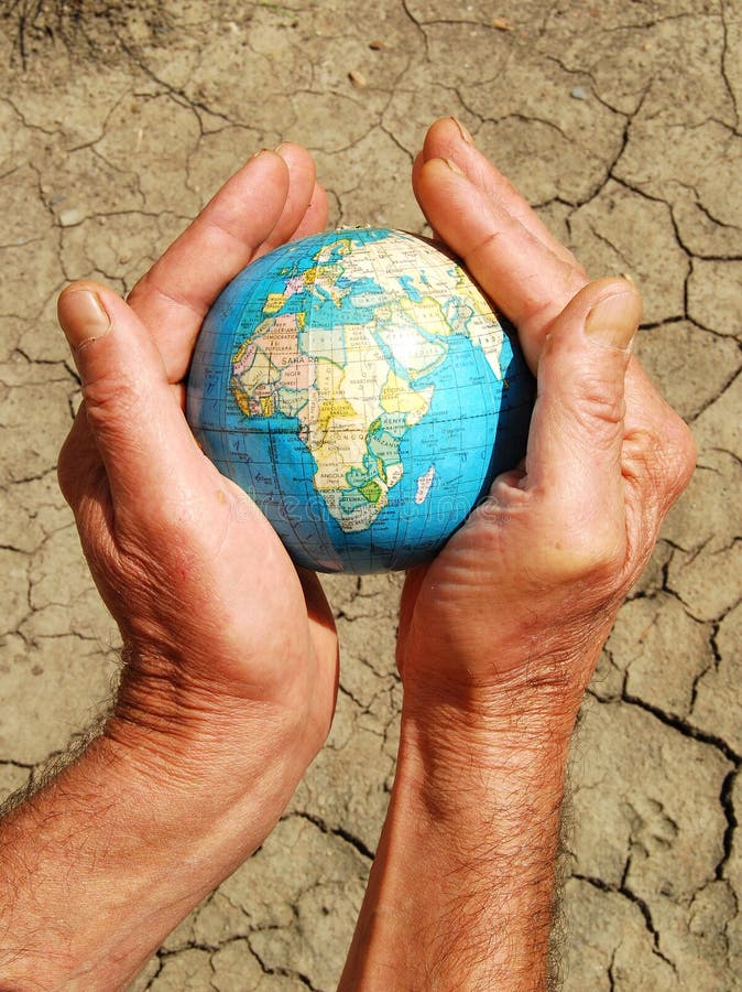 Save the world concept: earth supported by human hands on a dry land texture. World climate change stock images, royalty-free photos and pictures