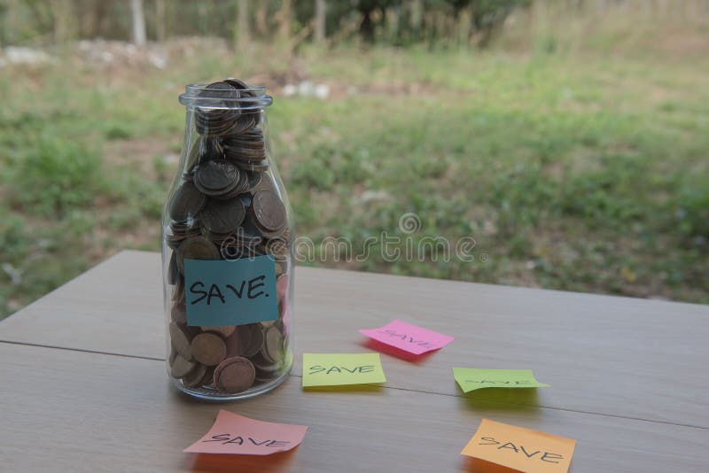 “Save†που γράφει στο έγγραφο, νομίσματα σε ένα βάζο γυαλιού στοκ εικόνες με δικαίωμα ελεύθερης χρήσης