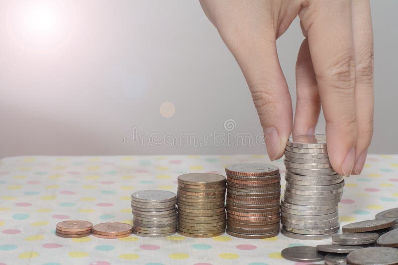 Saving money concept present by Female hand putting money coin stack growing business on white, Money, Financial, Busines stock photo