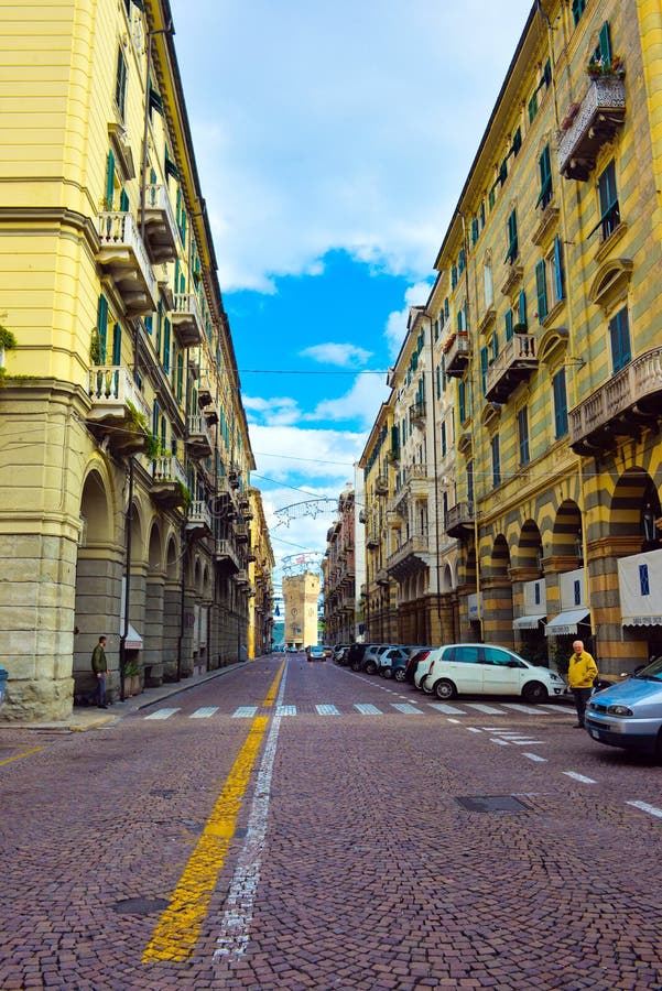 Savona klockatorn, gata med gula byggnader, lopp Italien, italiensk tappningarkitektur royaltyfri fotografi Savona klockatorn, gata med gula byggnader, lopp Italien, italiensk tappningarkitektur royaltyfri fotografi